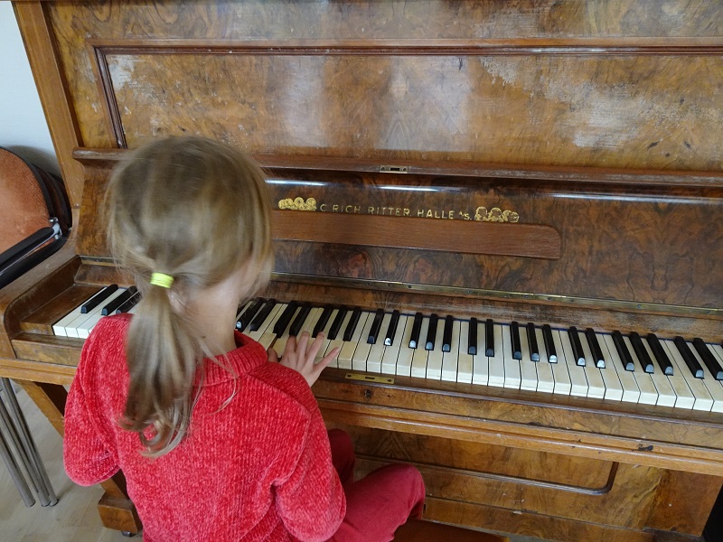 Die Kinder bringen sich gegenseitig das Klavierspielen bei
